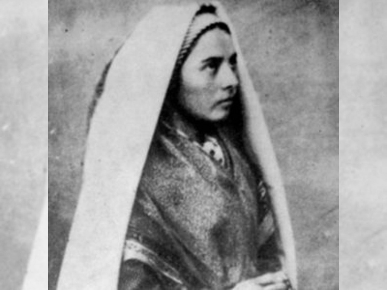Imagem em preto e branco que mostra Santa Maria Bernadete olhando para o céu