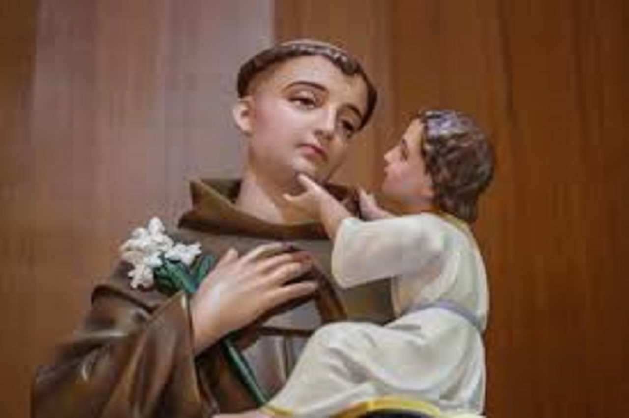 imagem de Santo Antônio segurando o menino Jesus no colo e um lírio representando a pureza.