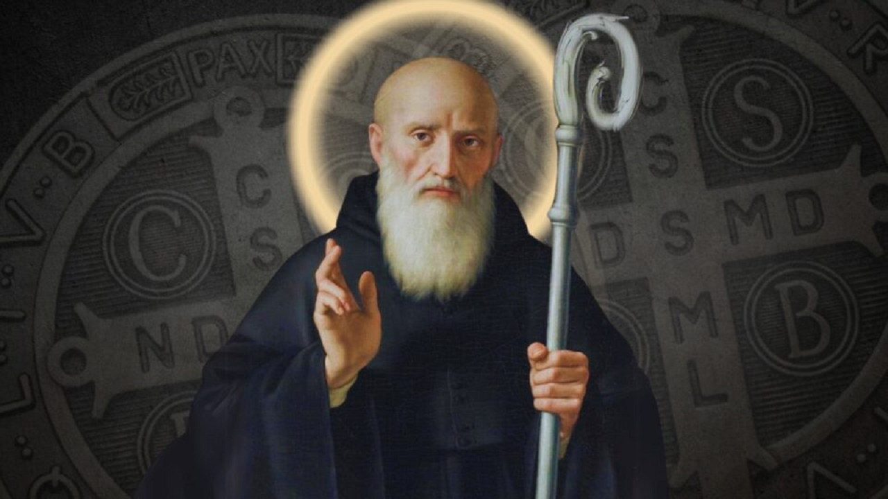 imagem de São Bento segurando o cajado e com as medalhas da cruz sagrada atrás