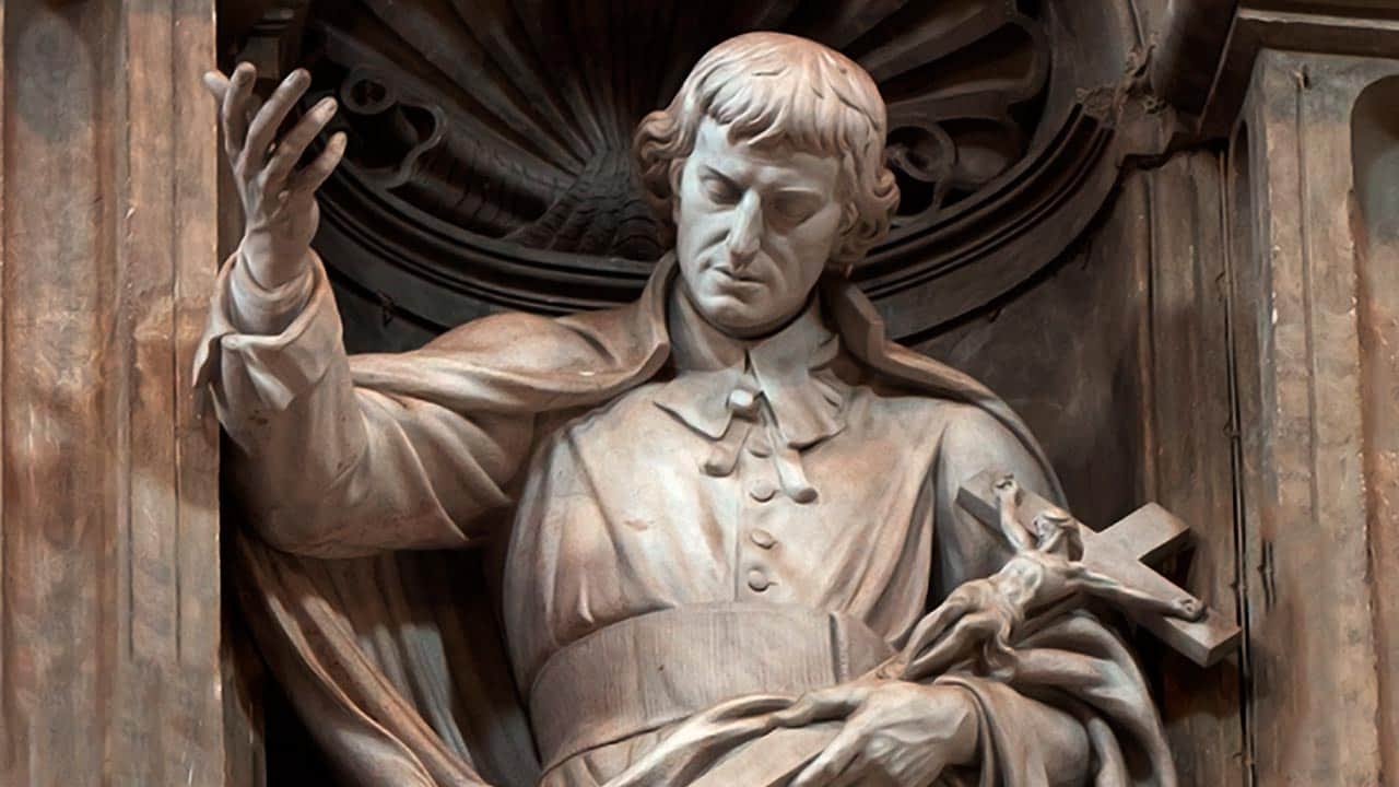 imagem do São Luís Maria de Montfort em Pedra e com a mão erguida para o céu e na outra com a cruz